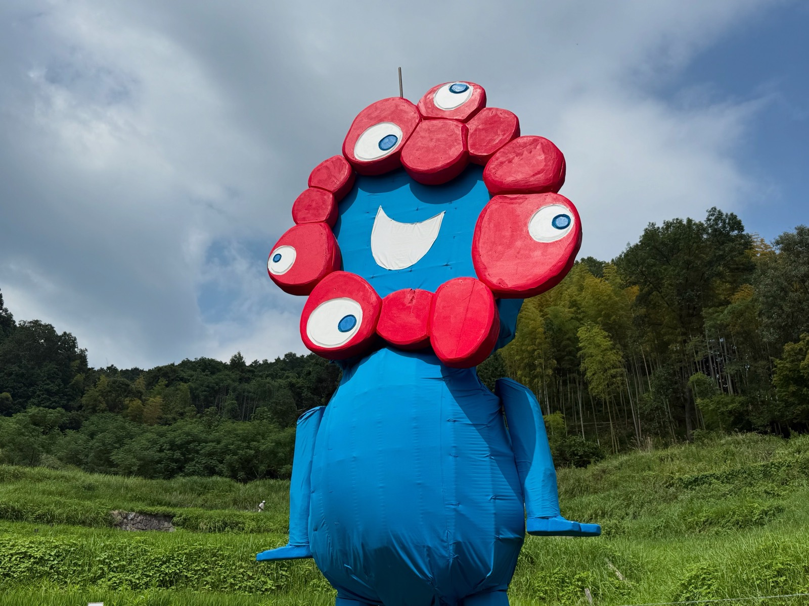 青い体に赤い目の連なりを頭に載せた、みゃくみゃくの形をしたジャンボ案山子