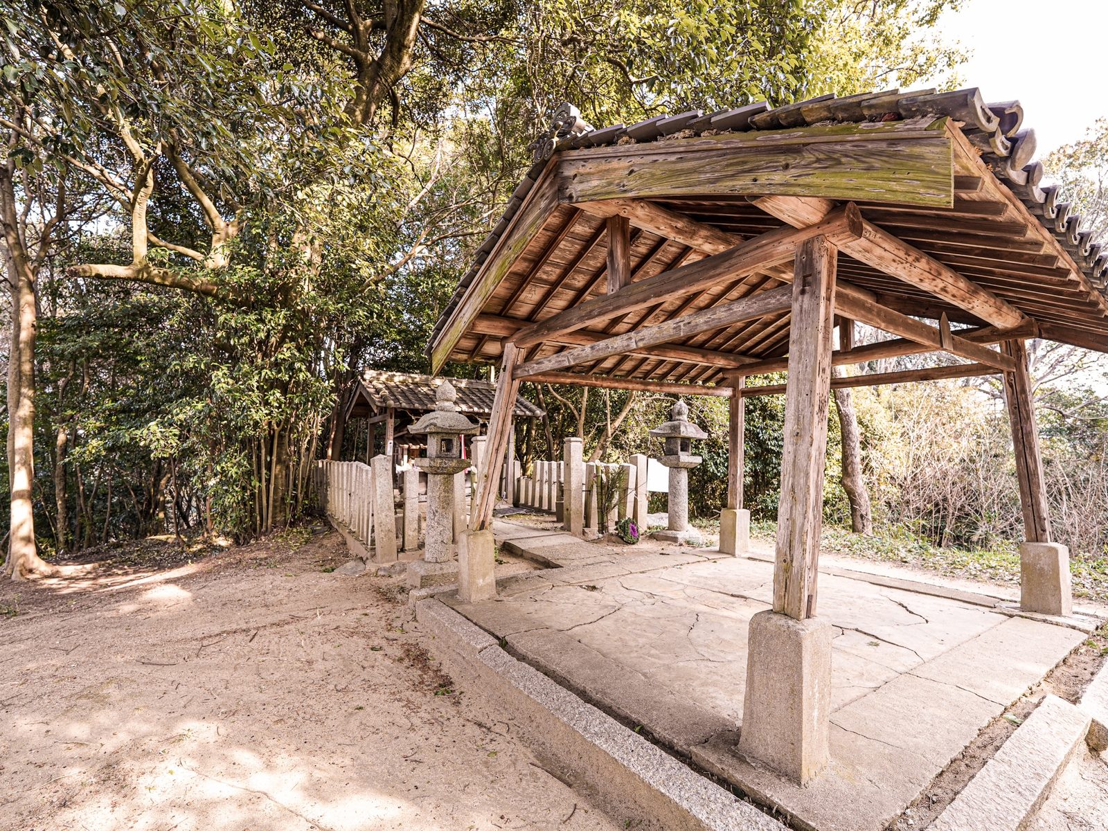 天香久山の山頂に鎮まる国常立神社。石敷きの床に屋根を架けた覆屋の奥に、玉垣に囲まれた小さな社と石灯籠