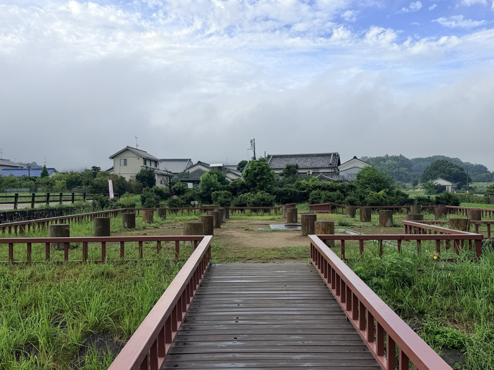 飛鳥水落遺跡の全景。木道の先に、建物の柱の位置を示す円柱が方形に並ぶ