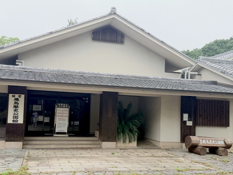 瓦屋根の飛鳥歴史公園館の外観。入口の左に「国営飛鳥歴史公園館」の看板が立つ