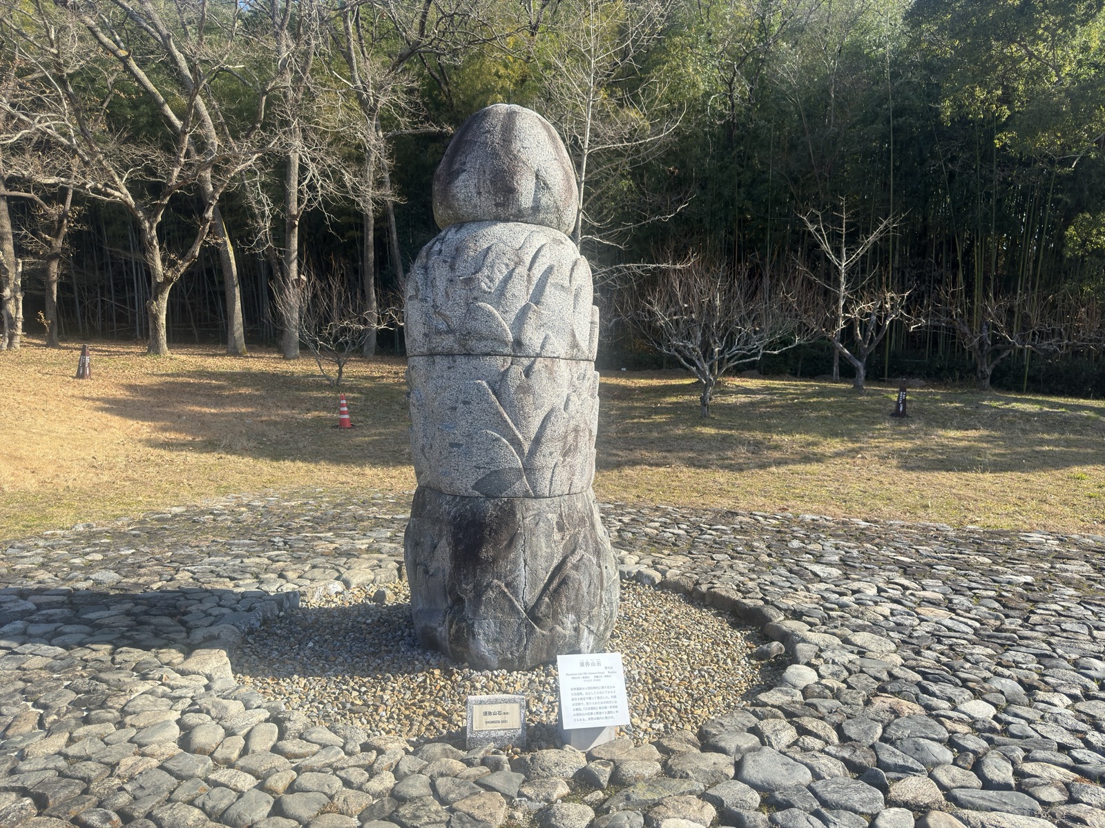 庭園に立つ須弥山石の複製。石敷きと玉砂利に囲まれ、奥は竹林