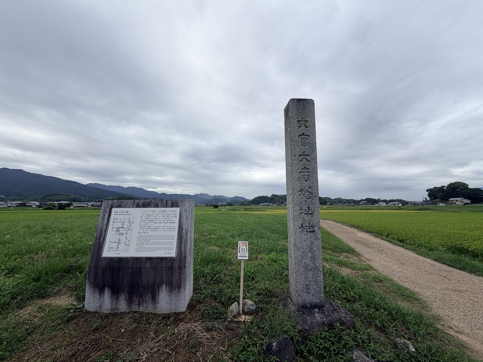 「大官大寺塔址地」の石柱と、明日香村が立てた「史跡 大官大寺跡」の説明板