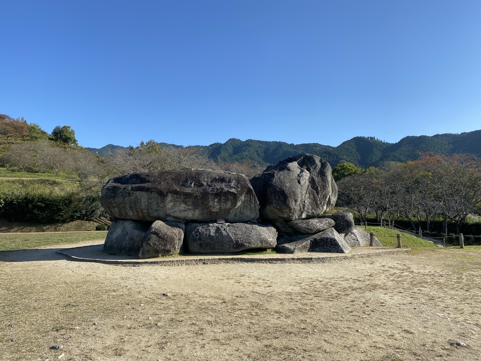 晴天の日中に南西側から見た石舞台古墳。奥に多武峰の山並み