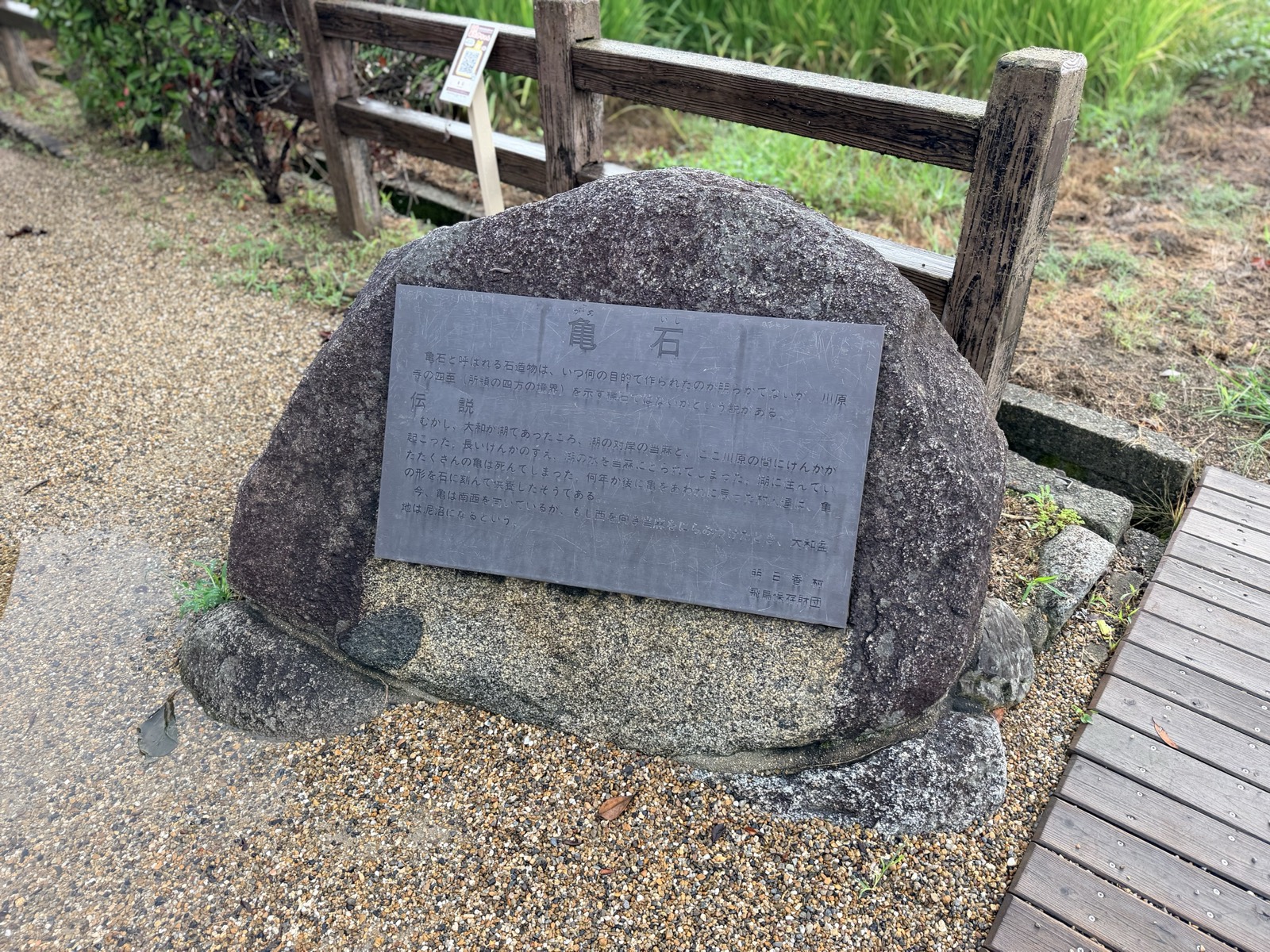 亀石のかたわらに置かれた明日香村・飛鳥保存財団の説明板