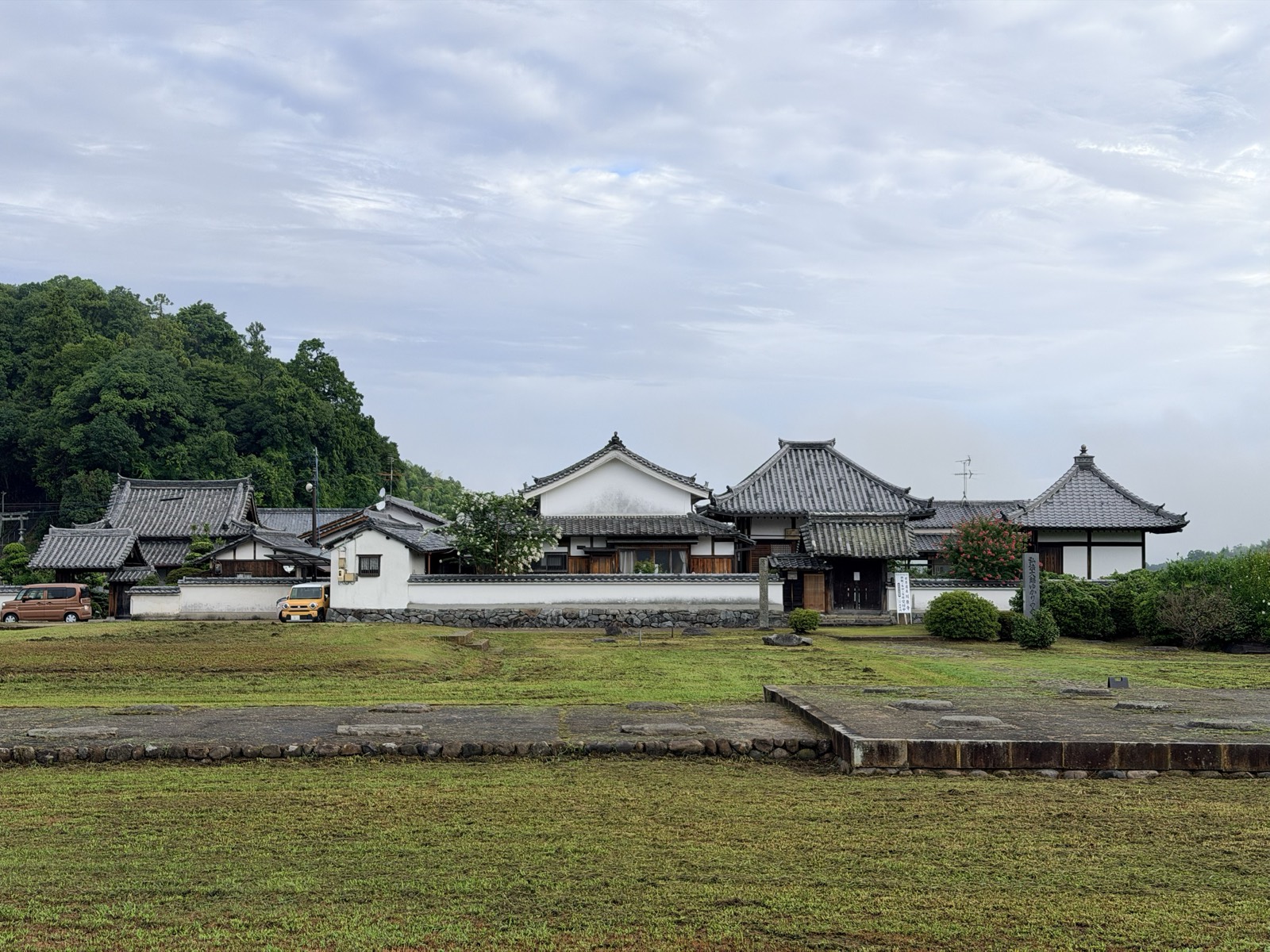 川原寺跡の礎石が並ぶ広場と、その奥に建つ弘福寺の伽藍