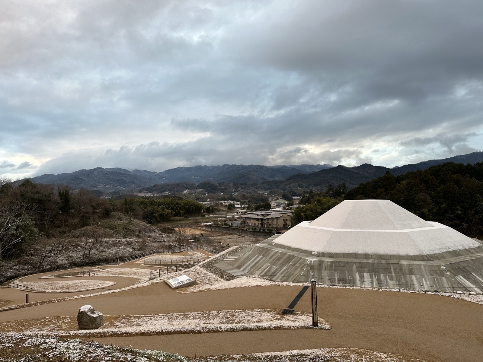 薄く雪の積もった牽牛子塚古墳。左手前は越塚御門古墳の跡
