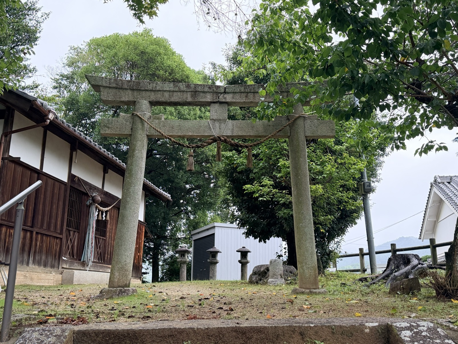 天神社（御園）の石鳥居。注連縄が張られ、奥に社殿と石燈籠が並ぶ
