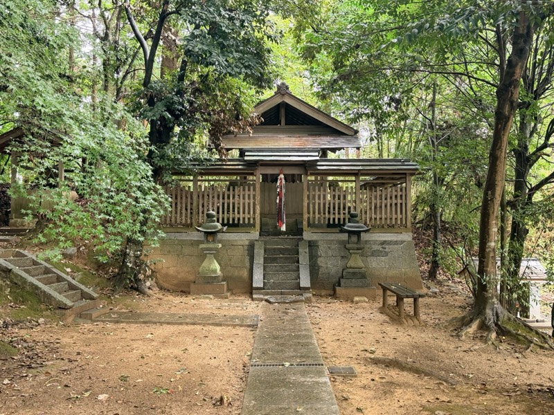 石垣の上に建つ小泊瀬稚雀神社の社殿。木の玉垣に囲まれ、正面の階段に紅白の御幣が下がる