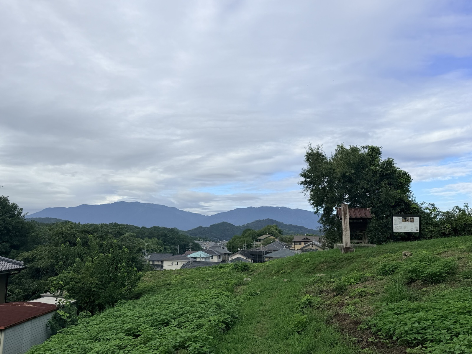 菖蒲池古墳の丘からの眺め。手前に集落の屋根、奥に山並み