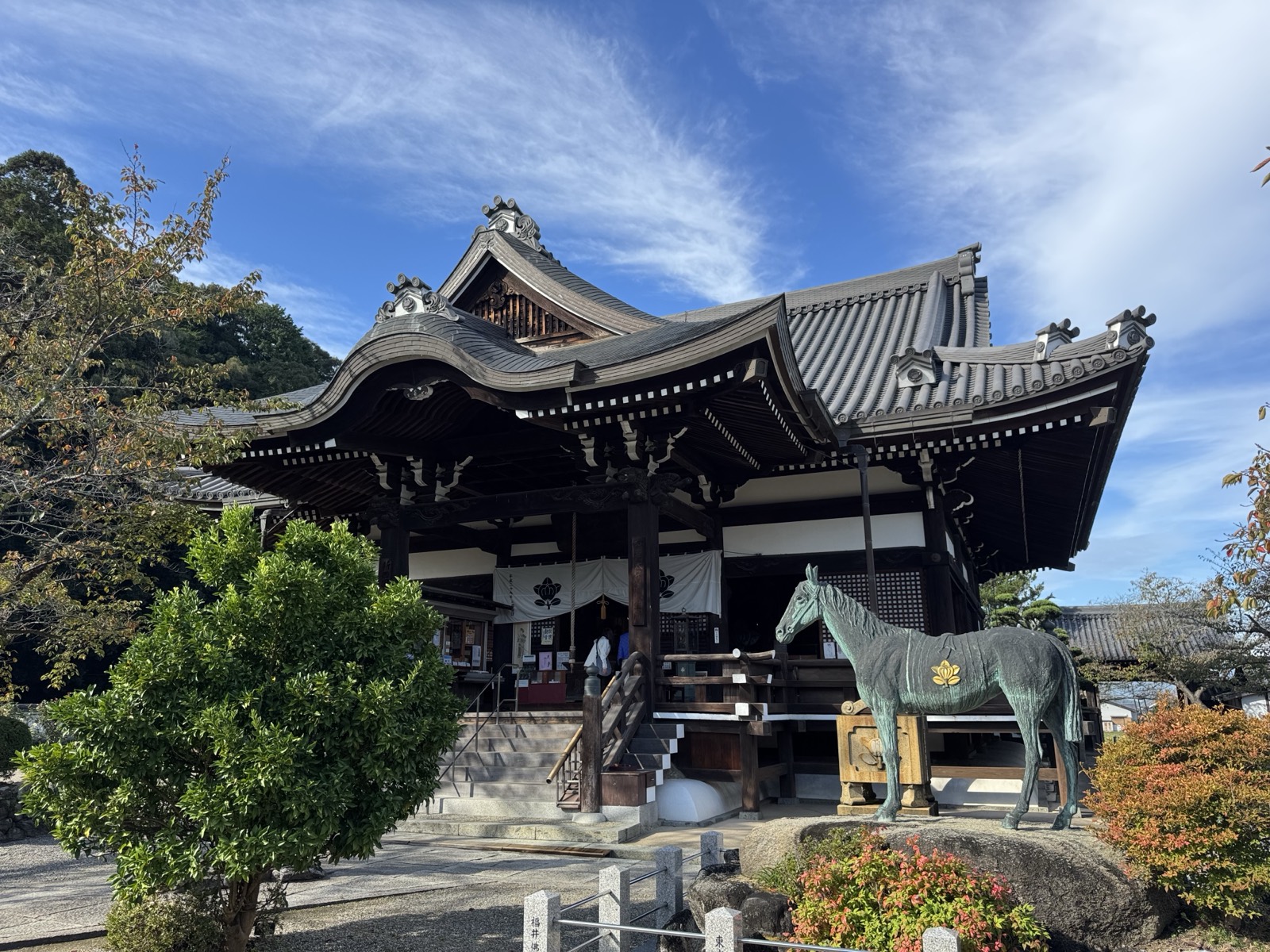 橘寺の本堂。手前に、聖徳太子の愛馬と伝わる黒駒の銅像が立つ