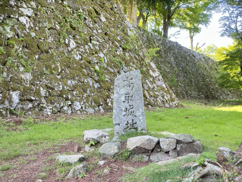 「高取城址」と刻まれた石碑と、苔むした高い石垣