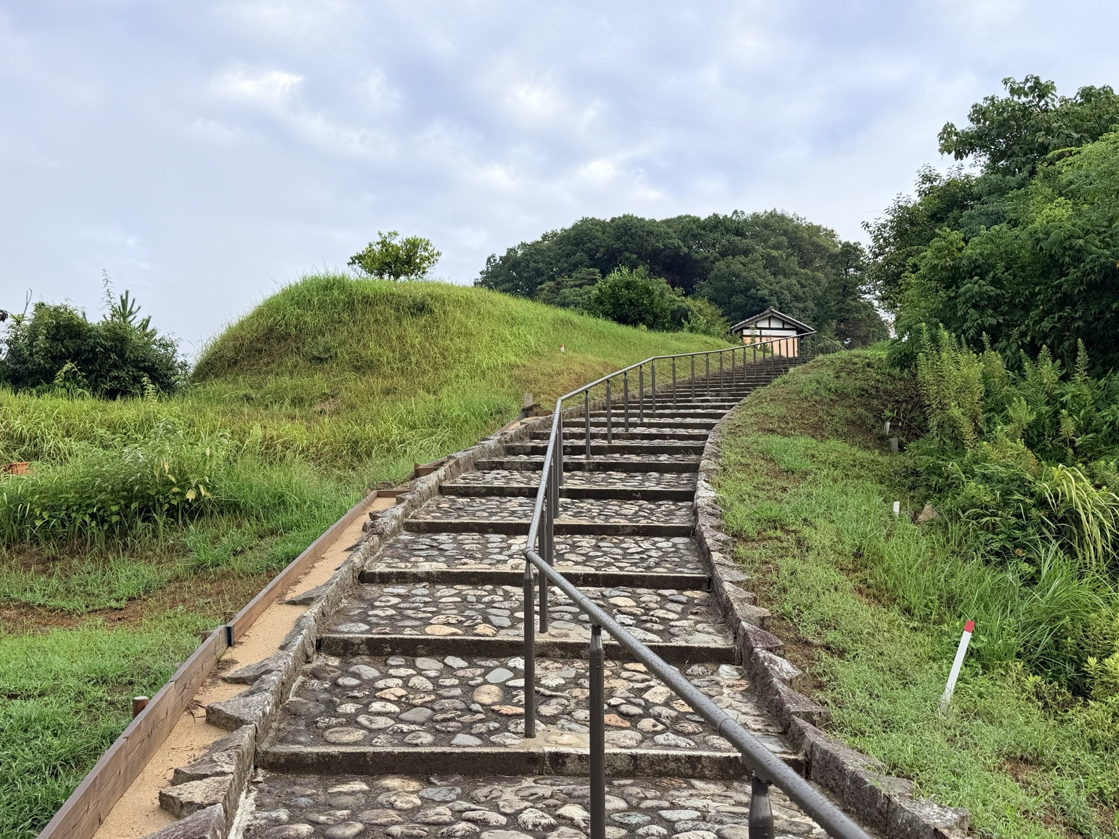 拝所へ続く石畳の階段。左に草に覆われた墳丘の斜面が見える