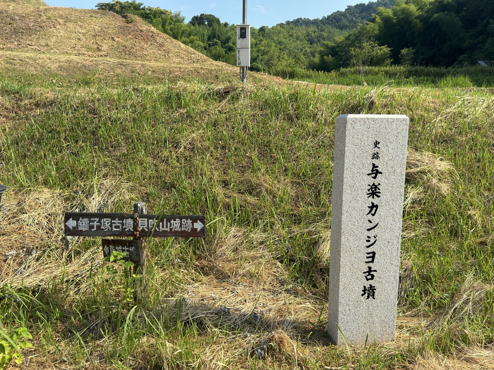 「史跡 与楽カンジョ古墳」の石標と、鑵子塚古墳・貝吹山城跡を示す木の道標